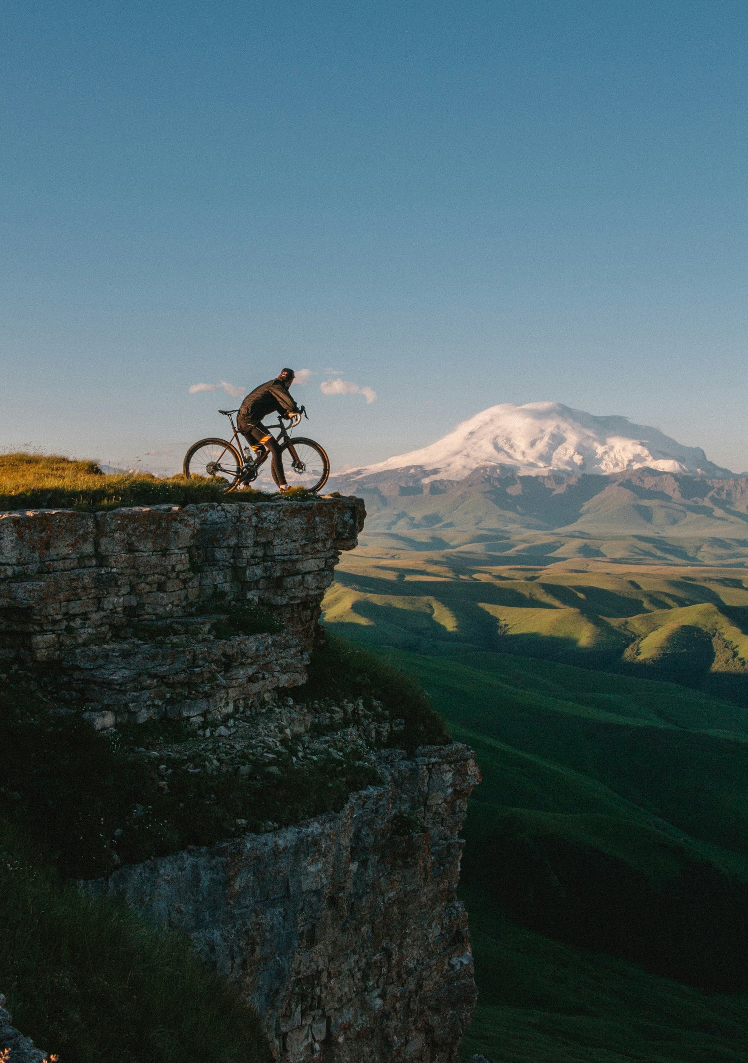 Person on a bicycle at the edge of a cliff with a mountain in the background for Brand Elk Sports Nutrition