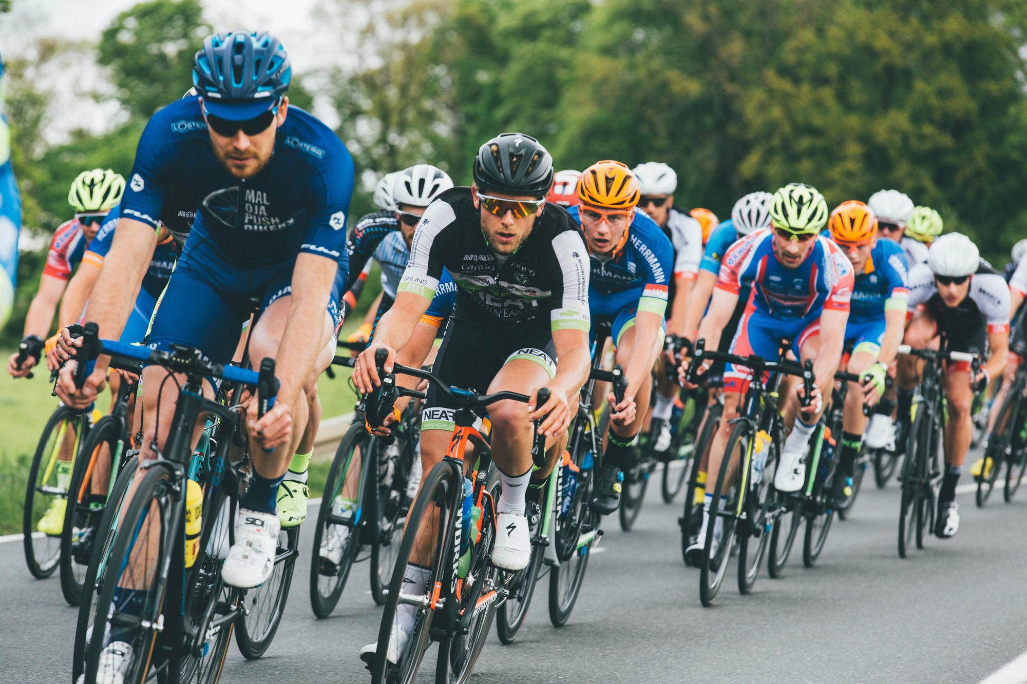 Cycling race with multiple cyclists on a road for brand Ek Sports Nutrtion.